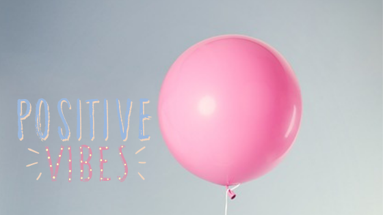 różowy balonik i napis "positive vibes"