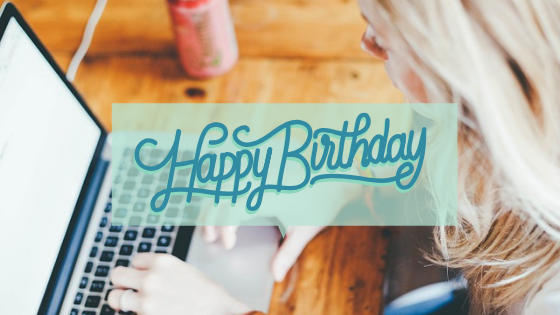 Kobieta pisze na laptopie i ozdobny napis "happy birthday"