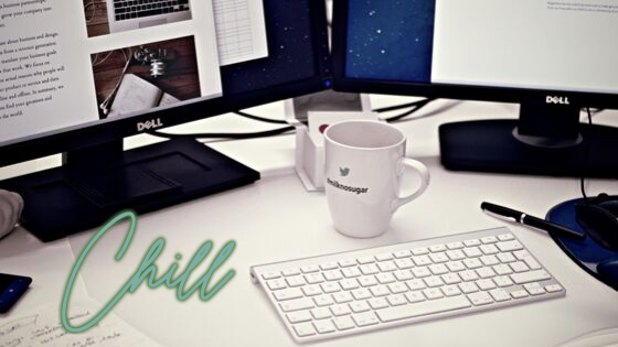 Biurko z monitorem komputera, kubkiem, klawiaturą 