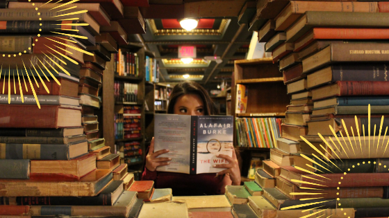 Kobieta czytająca książkę, wśród półek zapełnionych książkami.