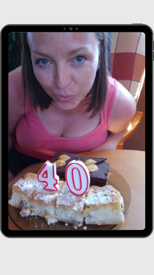 ciasto ze świeczkami - numerem "40", kobieta patrzy w obiektyw i udaje, że zdmuchuje te świeczki.